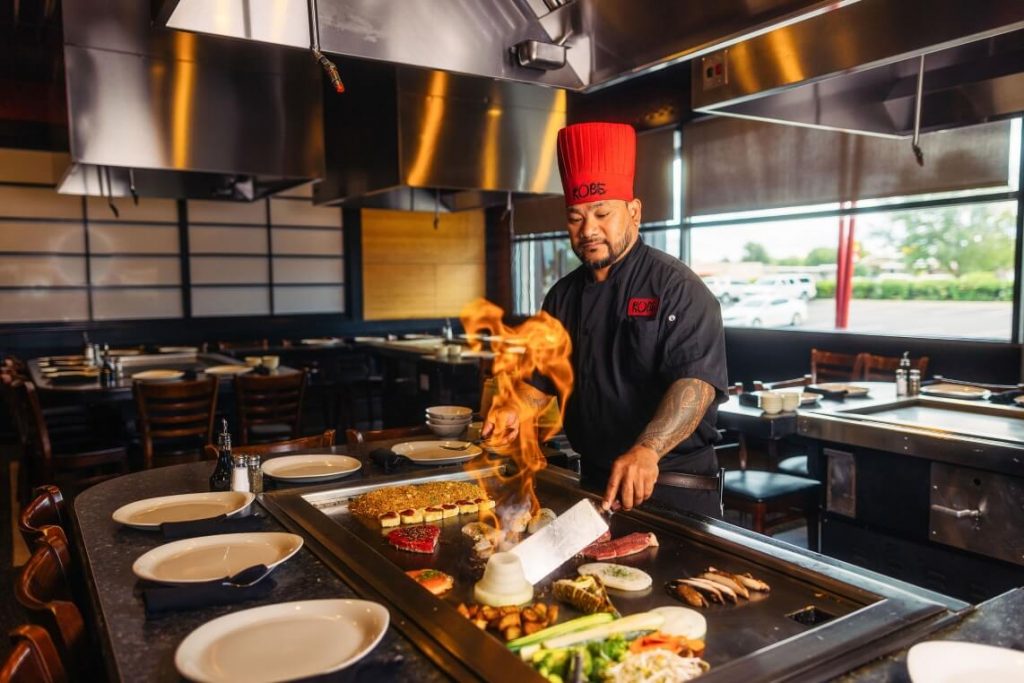 Kobe chef cooking on grill, creating a "flaming volcano"